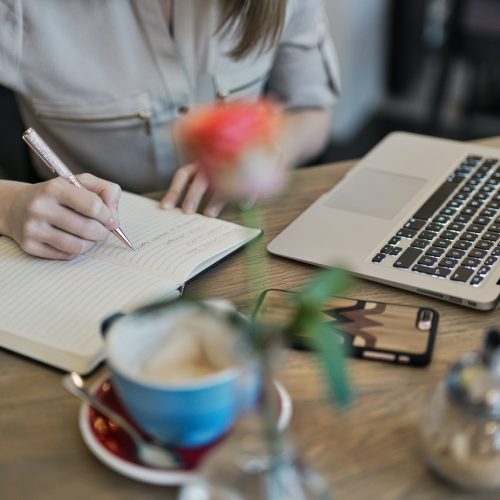 person-writing-on-a-notebook-beside-macbook-1766604 person-writing-on-a-notebook-beside-macbook-1766604